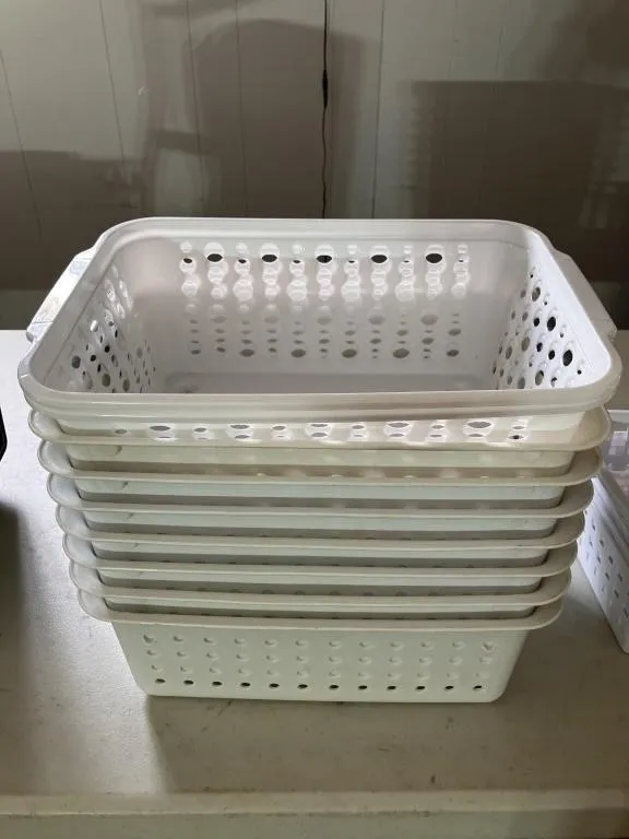 Thirteen assorted plastic organizer baskets. Nine