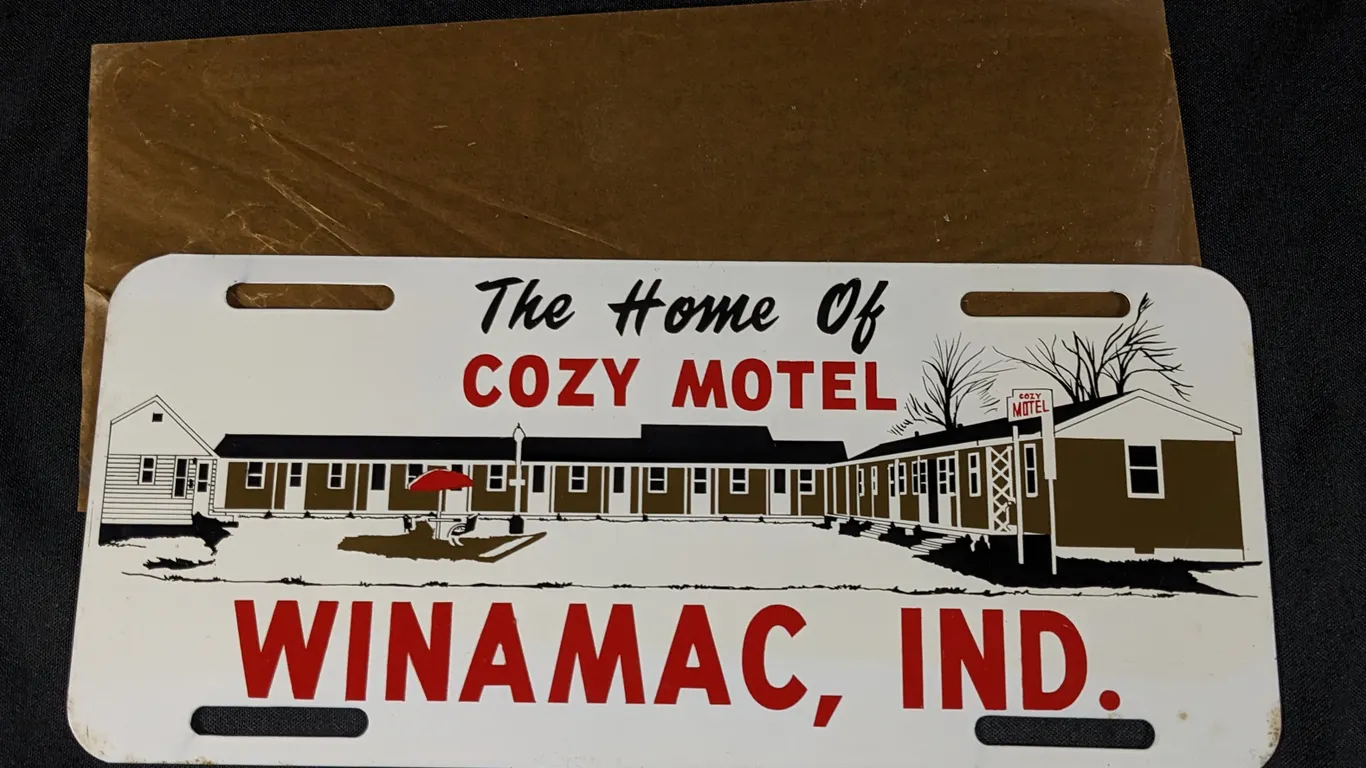 NOS TIN LICENSE PLATE TOPPER SIGN THE HOME OF COZY MOTEL WINIMAC IND IN INDIANA