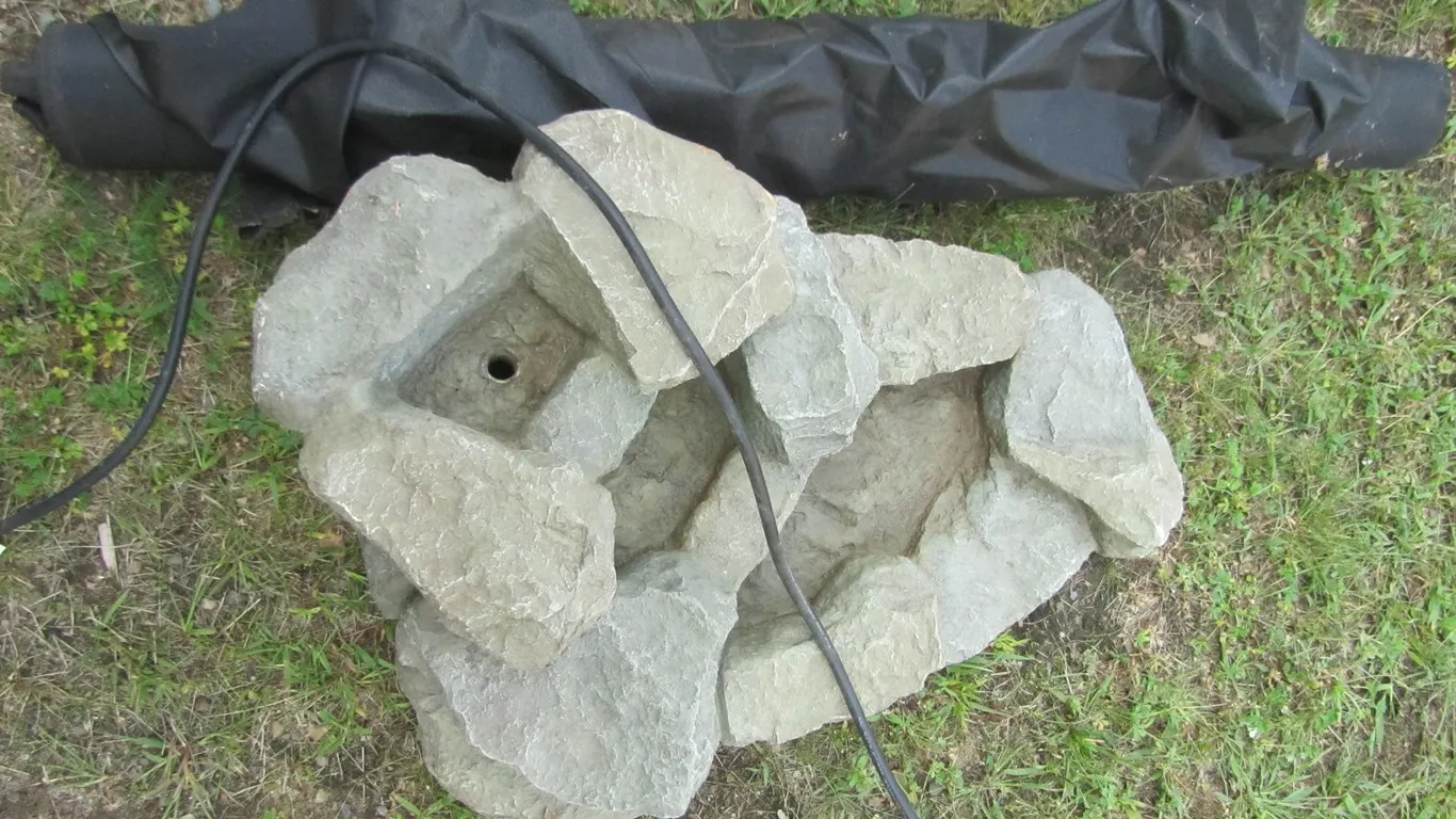 Water Fountain And Partial Roll Of Landscape Fabric
