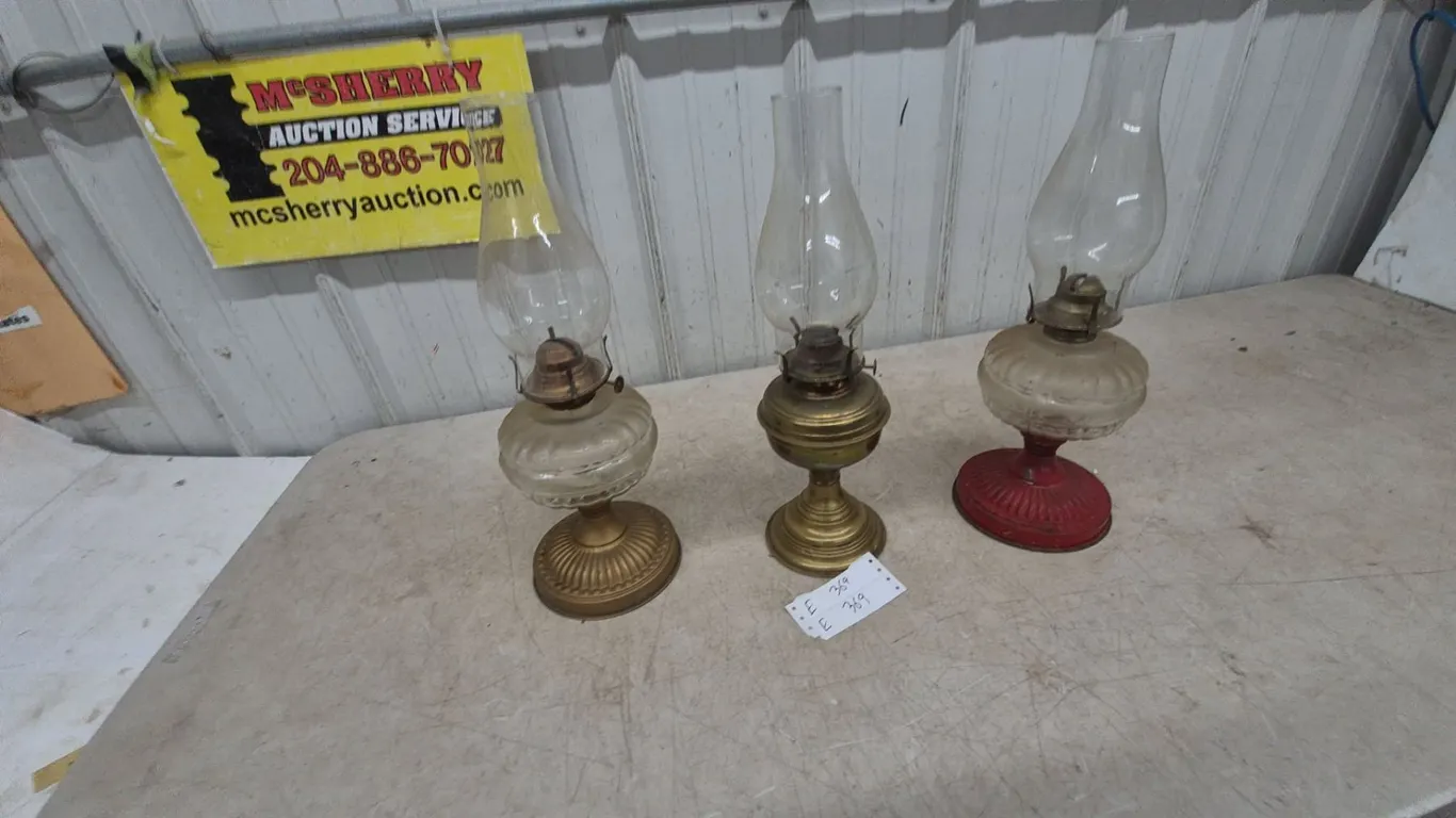 Three Oil Lamps: 1 Brass Base and Clear Glass Font, 1 Brass Base and Clear Glass Font, 1 Red Base.