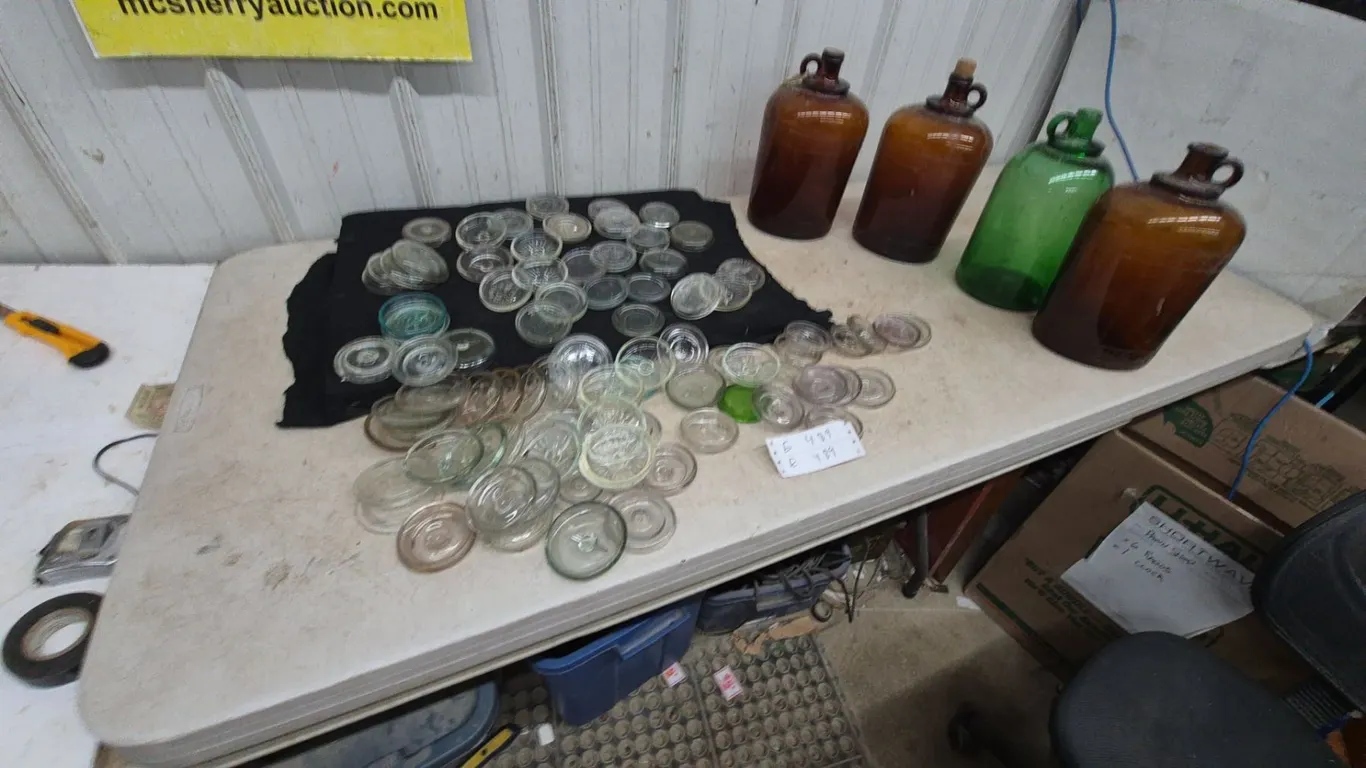 Assorted Glass Jar Lids and 4 Glass jugs: 2 Amber, 1 Green, 1 Brown
