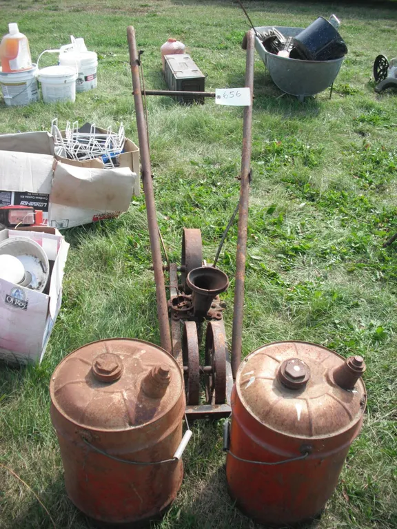 2 metal gas cans and cast iron seeder