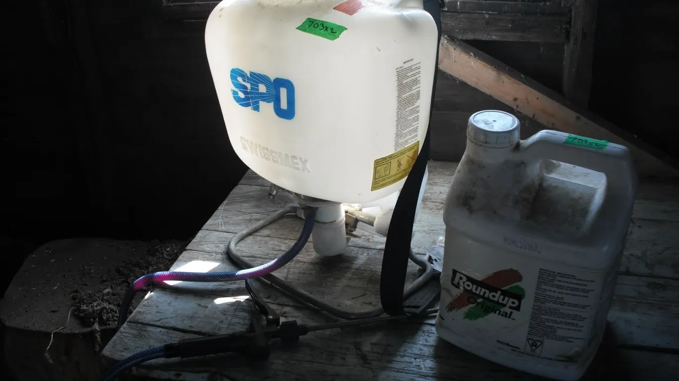 partial jug of roundup and backpack sprayer