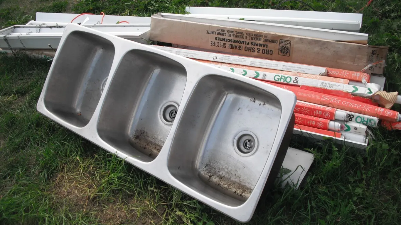 lot of halogen bulbs, light fixtures and 3 bay stainless steel sink