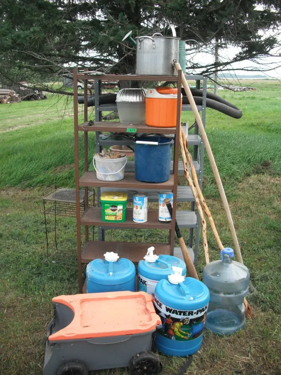 2 shelves, water jugs, garden tools, electric fencer, etc.