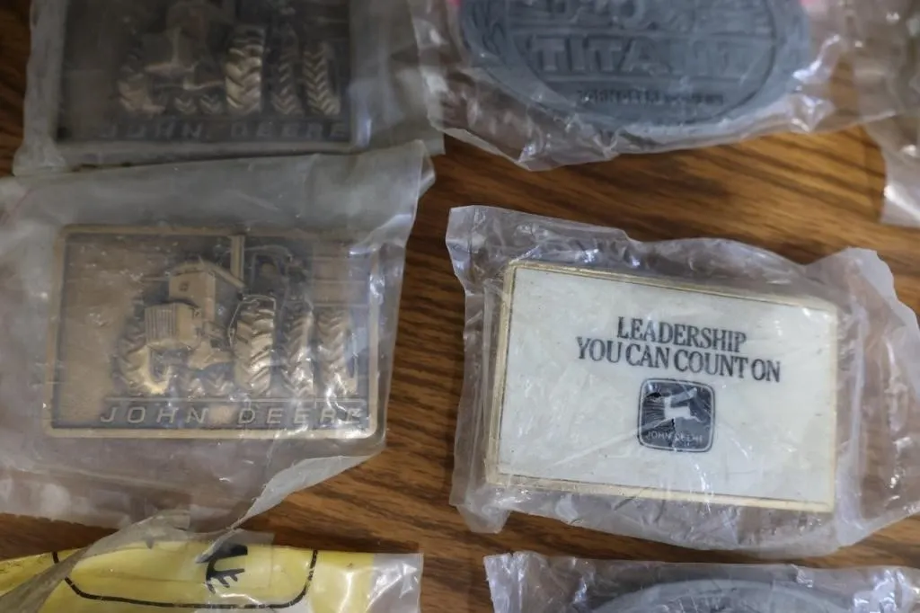 Twelve John Deere collector belt buckles