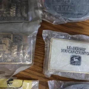 Twelve John Deere collector belt buckles