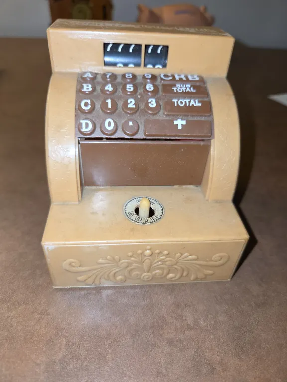 cash register shaped bank, hand comes out and hand pulls money...works