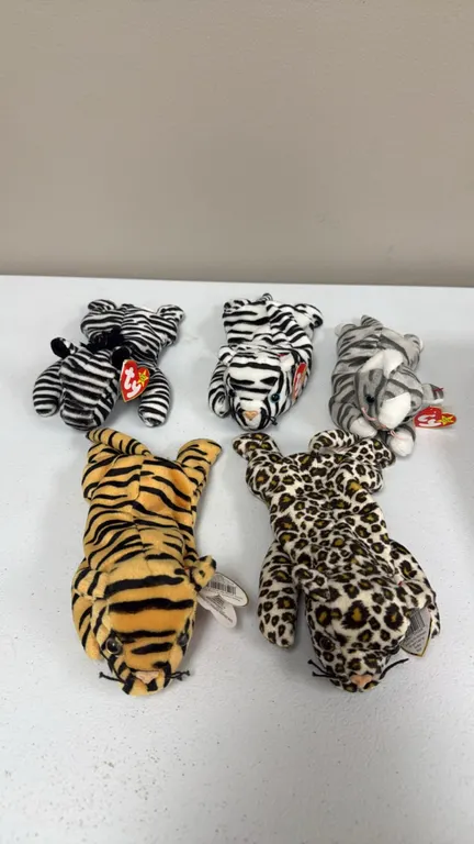 A Collection of Ty Beanie Babies Plush Toys. (Ty, 1990s) A set of five animal print plush figures including Stripes the tiger, Freckles the leopard, Z