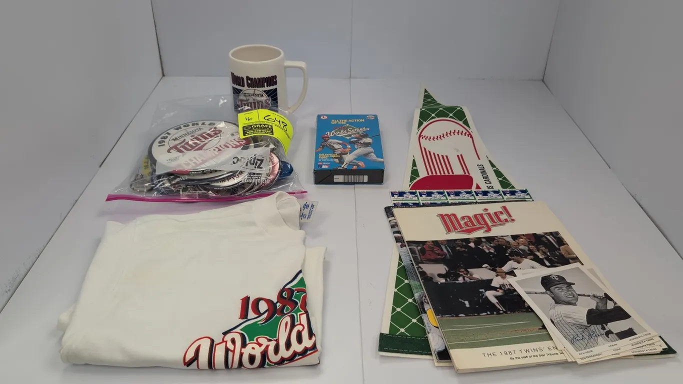 A Collection of Minnesota Twins 1987 World Series Memorabilia. (MLB, 1987) Includes an XL Logo 7 t-shirt, ceramic mug, felt pennant, sealed VHS tape,