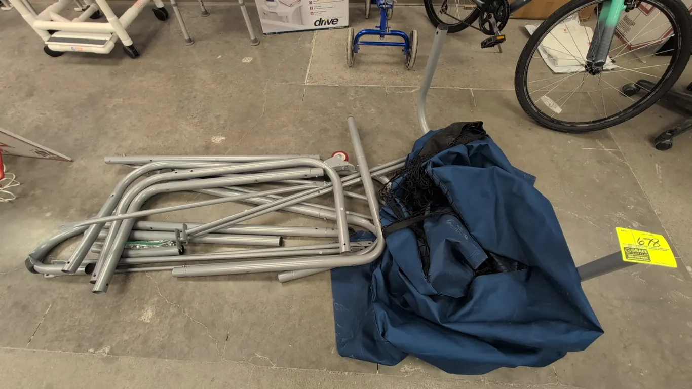 Portable net system with metal frame. Features gray tubular metal frame sections with push-button snap assembly, integrated base wheels/casters, and b