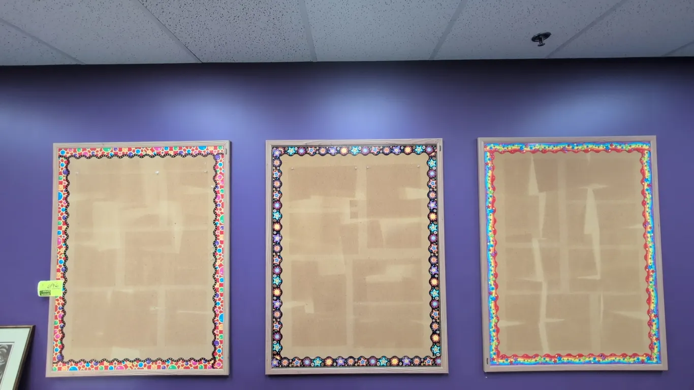 Wood-framed corkboards. Features natural cork bulletin surface, light wood frames, and decorative border trim. 46" x 36" each. Wall mounted.