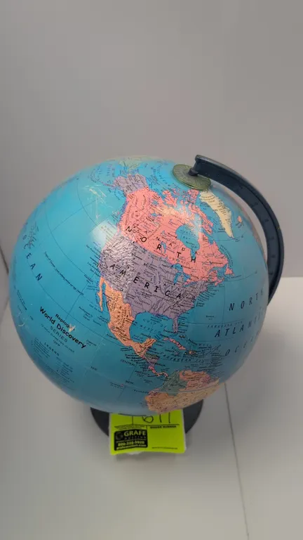 Replogle World Discovery Series desk globe. Features raised relief topography, political boundaries, and time dial at North Pole. 12" diameter. Mounte