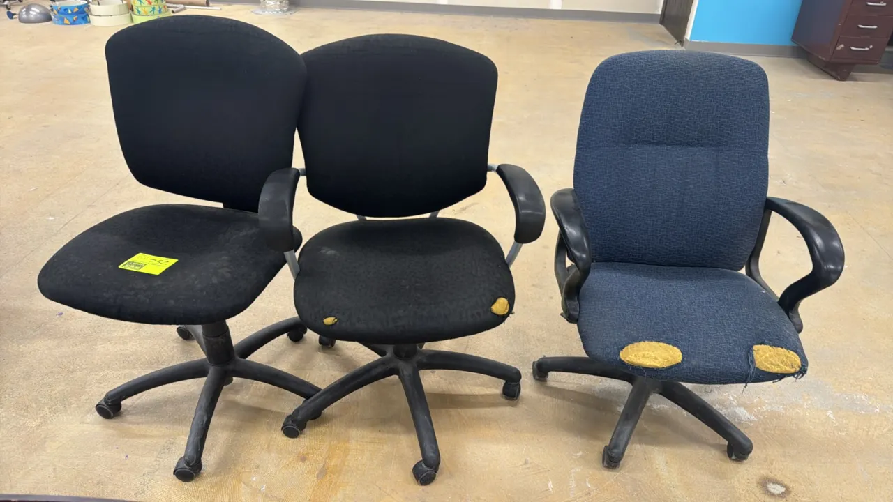 Assorted upholstered office task chairs. Includes (1) armless black chair, (1) black chair with armrests, and (1) blue fabric chair with armrests. Mou