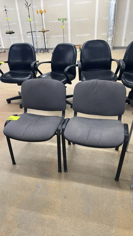 Padded metal frame side chairs. Features gray patterned fabric upholstered seats and backrests with black plastic back shells. Mounted on black metal