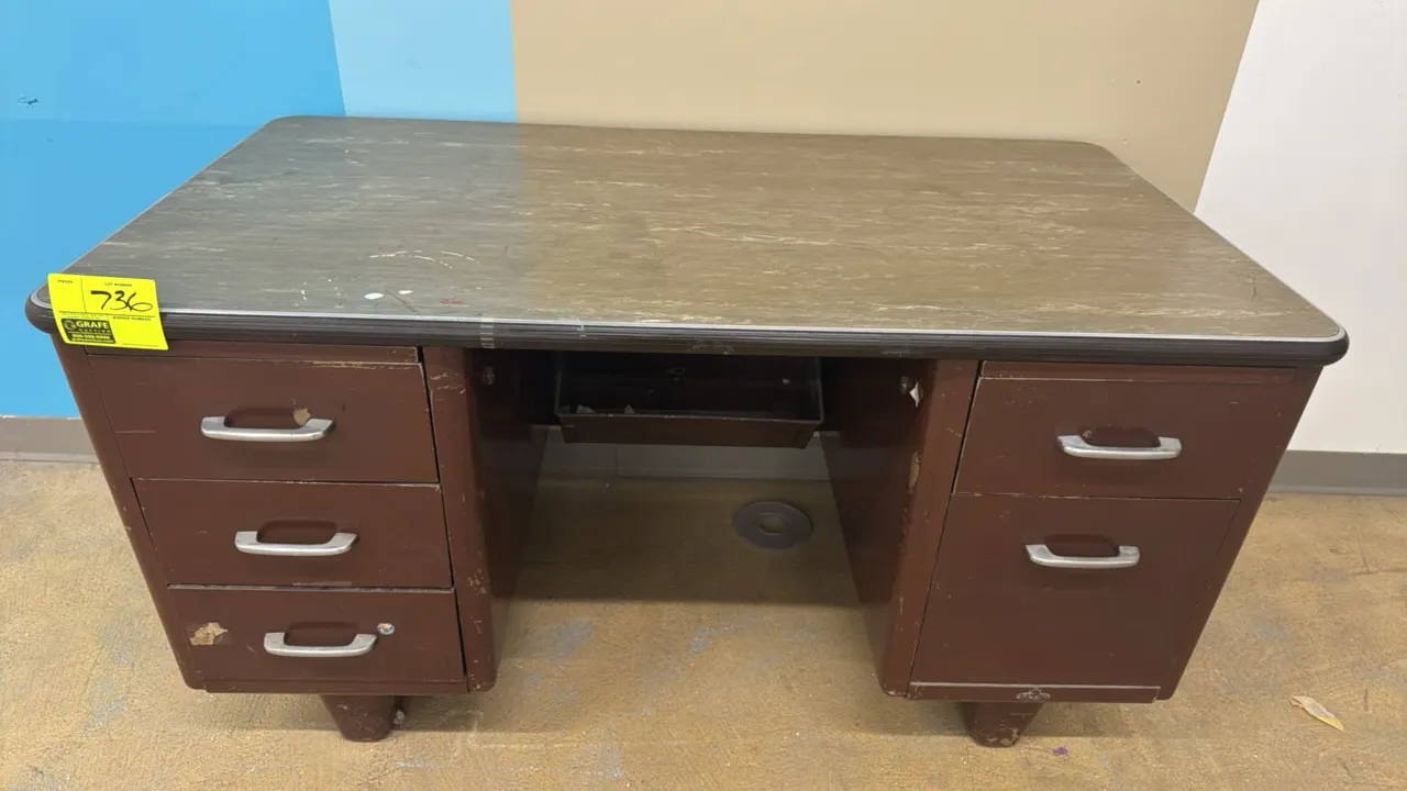 Double-pedestal metal desk. Features a brown metal frame, laminate work surface with protective edge trim, three left-hand drawers, two right-hand dra