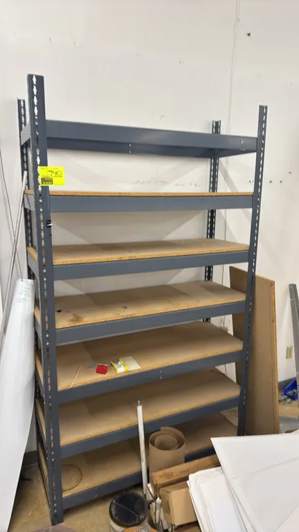 Metal 7-tier storage rack with particle board decks. Features adjustable shelf levels and gray painted frame. 48"x18"x84". Contents not included.