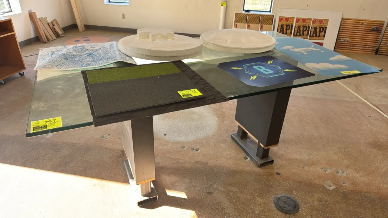 Custom glass top table. Features thick rectangular glass top supported by a steel I-beam crossmember and dual wood and metal pedestal legs. 80"L x 44"
