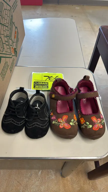 The Children's Place children's shoes. Includes (1) pair of black wingtip-style lace-up infant shoes (size 0-6 months) and (1) pair of brown Mary Jane
