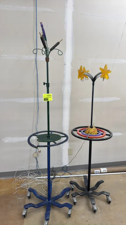 Mobile heavy-duty IV stands with artistic elements. Features decorative themed toppers including cattails and stars, integrated circular display tiers