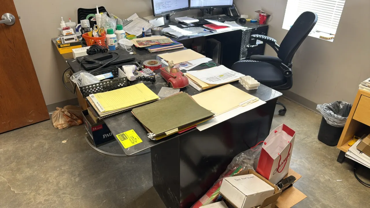 L-shaped wood desk with metal top and file cabinet. Features wood pedestal base and 2-drawer black metal file cabinet. 7' x 6'. Contents not included.