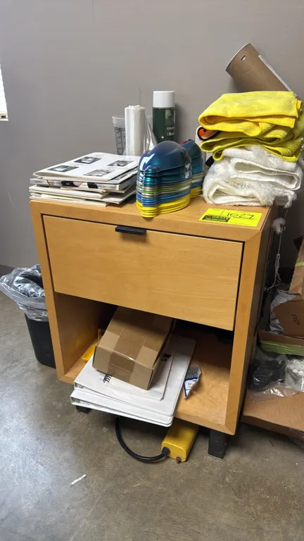 Wood storage cabinet. Features a single upper drawer with pull handle and an open lower storage compartment. Dimensions: 19" x 20" x 25". Mounted on b