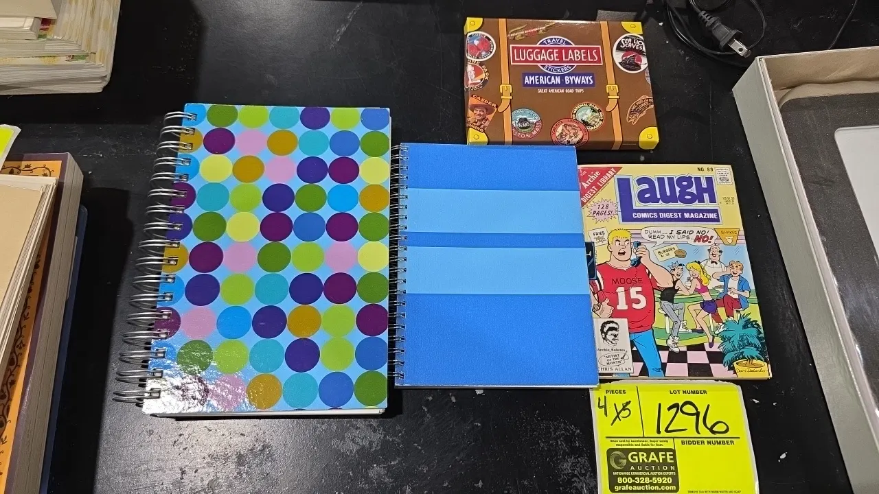 Assorted journals, comic magazine, and luggage label stickers. Includes spiral-bound notebooks with patterned covers, Archie Digest Library Laugh Comi