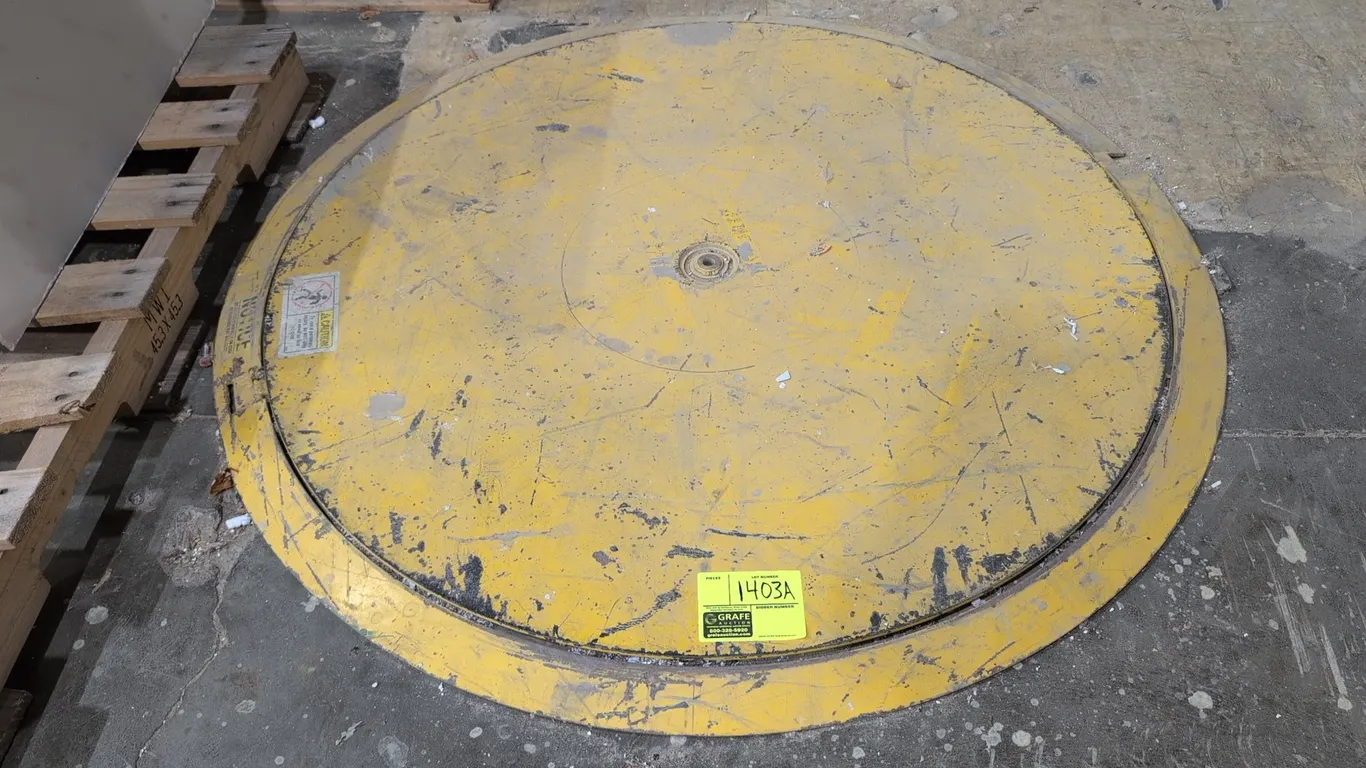Industrial low-profile metal turntable. Features steel construction with yellow painted finish, rotating center platform, and beveled outer ring. 48"