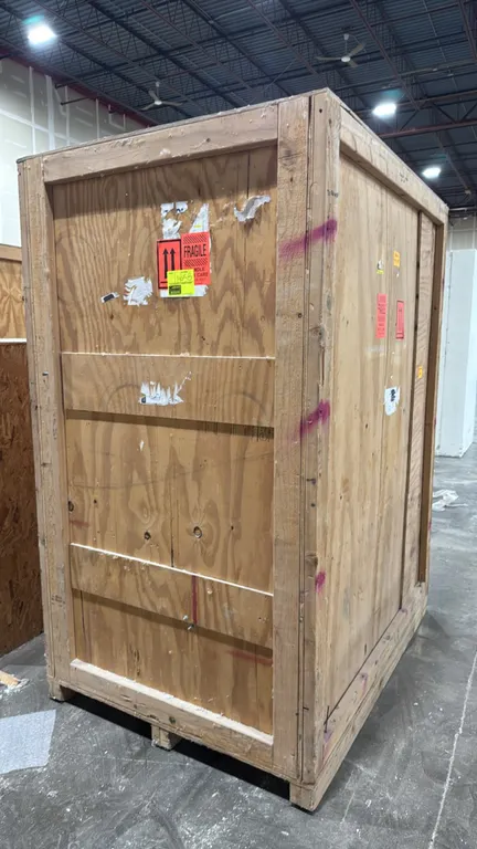 Wood shipping crate. Features plywood and dimensional lumber construction with an integrated pallet skid base. 63" x 46" x 82".