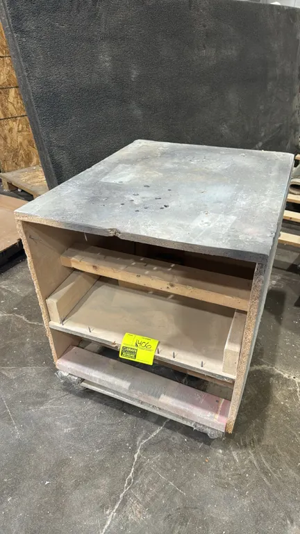 Wood portable work table and cabinet. Features composite and wood construction with interior shelving. Dimensions: 25" x 31" x 28". Mounted on casters