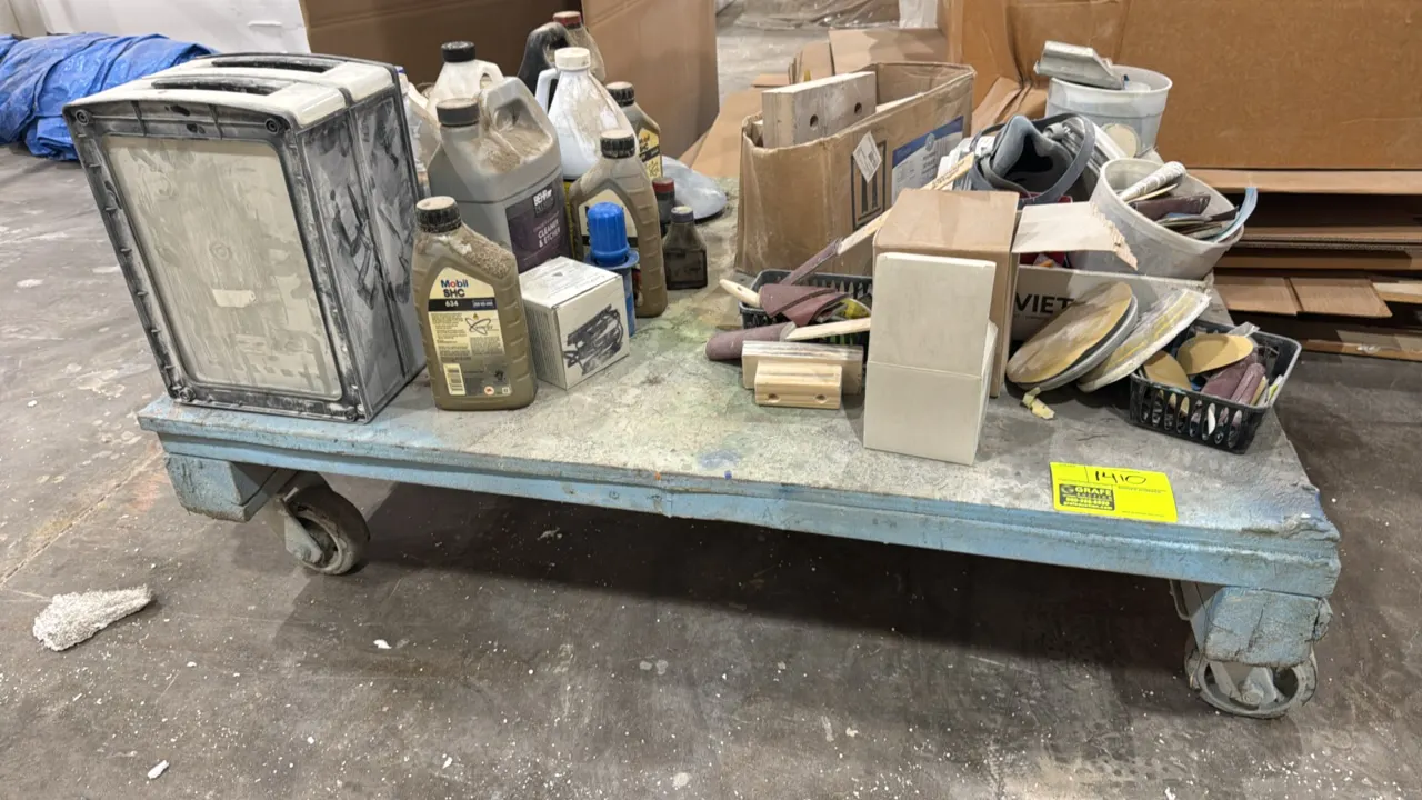 Wood platform cart with contents. Features painted wood construction and includes assorted workshop supplies including sanding blocks, abrasives, lubr
