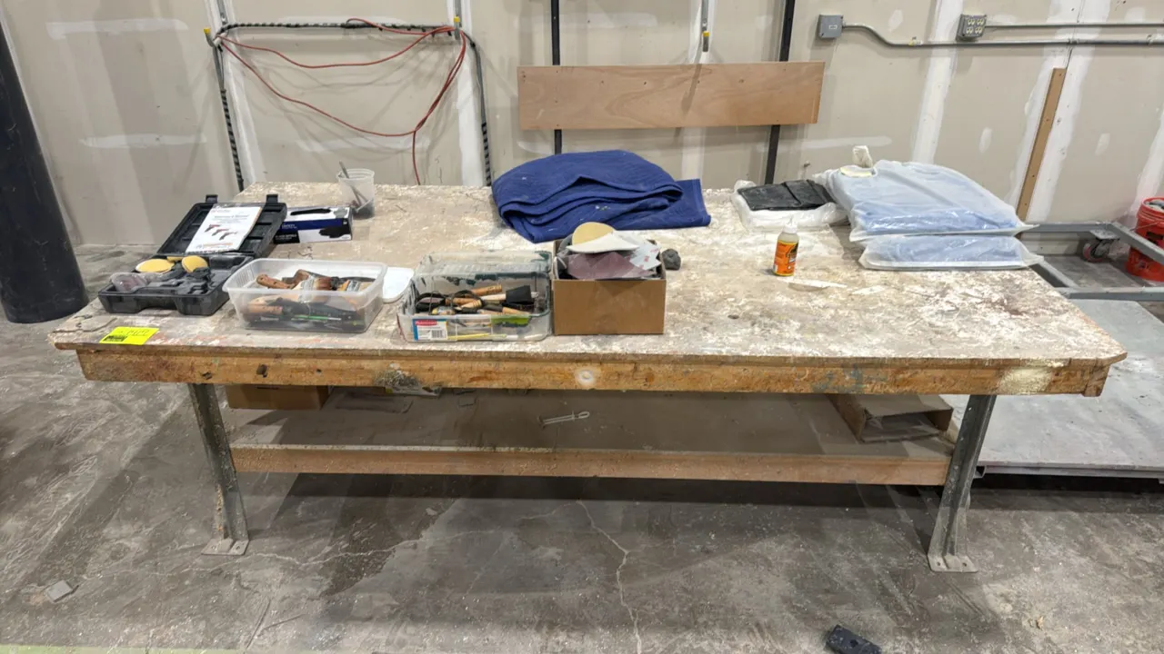 Wood work table with metal legs and lower storage shelf. 97" x 49". Includes contents: assorted hand tools, sculpting tools, paint brushes, sanding pa