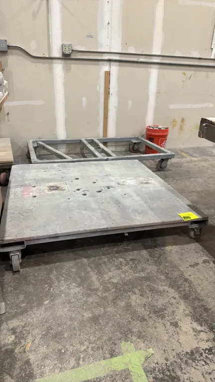 Metal 4-wheel dollies. Includes (1) solid deck platform dolly and (1) open steel frame dolly. Mounted on 4 swivel casters each. Dimensions: 4' x 4' an