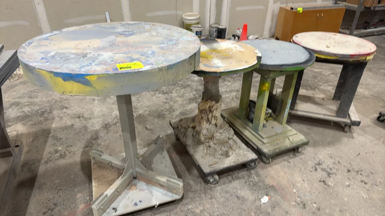 Assorted wood and metal work carts. Features circular work surfaces with mixed wood, metal, and composite construction. Three units mounted on caster