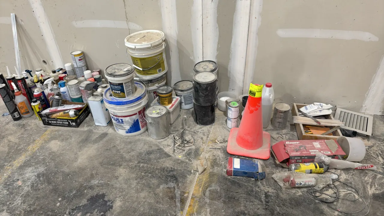 Package lot of assorted adhesives, caulk, paint, hardware, and supplies. Includes traffic cone, caulk tubes, spray foam and lubricants, paint cans, bu
