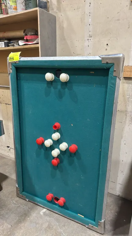 Brinktun bumper pool table top. Features green felt playing surface, red and white rubber bumpers, two goal pockets, woodgrain laminate exterior, and