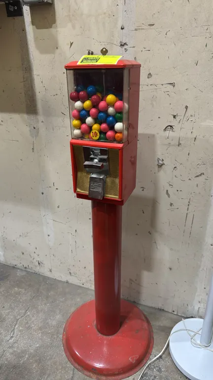 Northwestern 10¢ gumball machine. Features red metal housing, clear display globe, mechanical 10¢ coin mechanism, metal product dispensing flap, and k