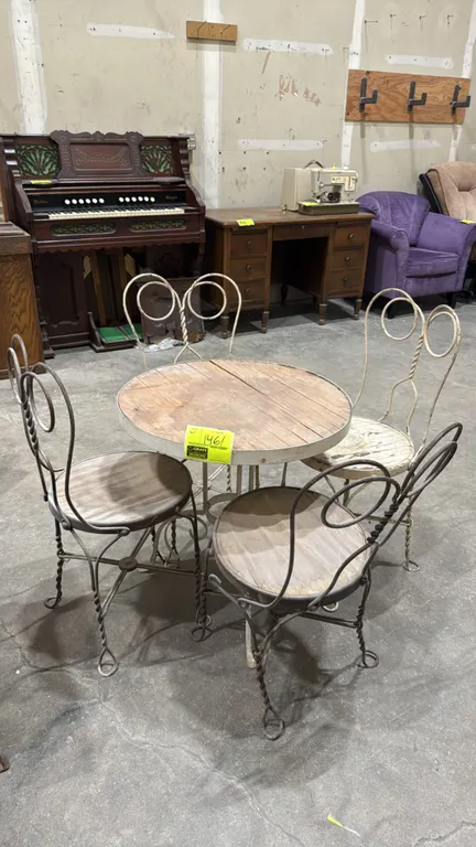 Vintage metal bistro table and chair set. Includes a 24" dia. round table with wood top on a twisted metal base, accompanied by (4) twisted wire sweet
