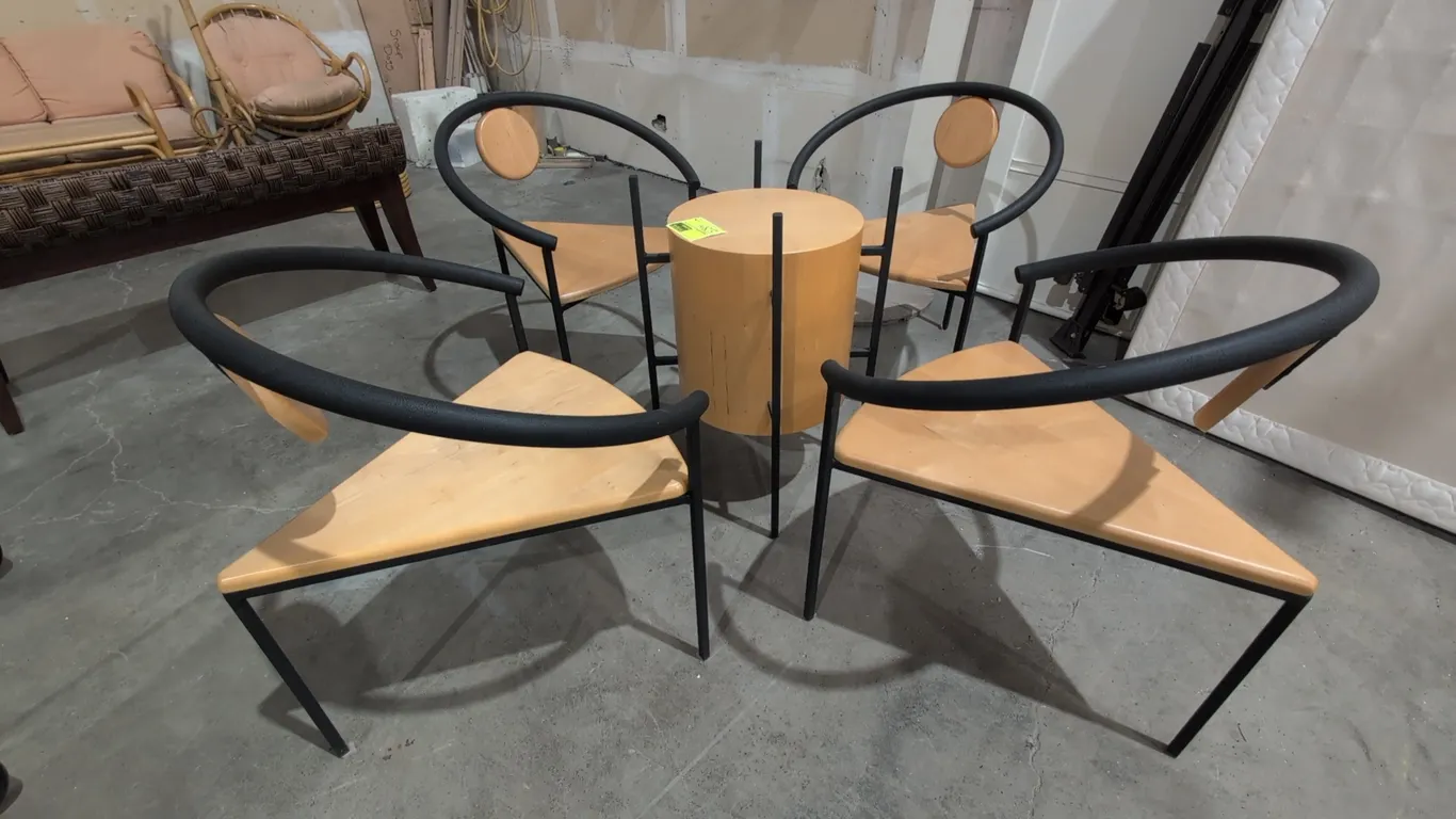 Postmodern wood and metal dining set. Includes (4) chairs and (1) small table. Chairs feature triangular light wood seats, black metal tubular frames,