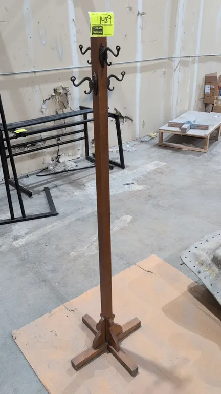 Wood coat rack. Features four dual-prong cast metal hooks and a four-point cross base with decorative support brackets. 65"H.