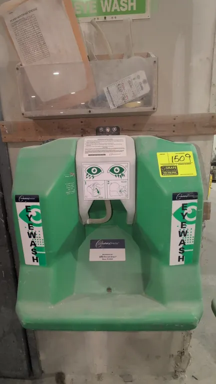 The Safety Director emergency eyewash station. Features green polyethylene tank, pull-down activation panel, and top threaded fill cap. Complies with