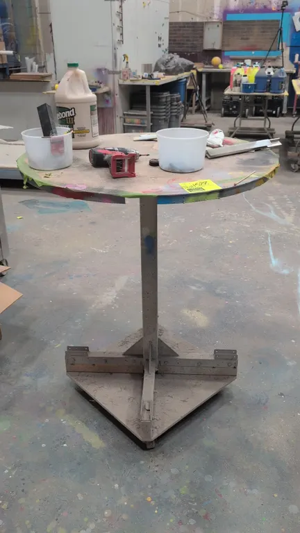 Portable laminate table. Features a round laminate top and steel pedestal base. 36" x 43"H. Mounted on casters. Contents not included.