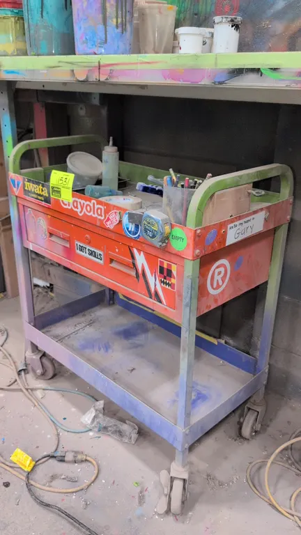 Metal 2-tier platform cart. Features a single storage drawer, top tray with dual handles, and lower shelf. 30". Mounted on swivel casters. Contents no