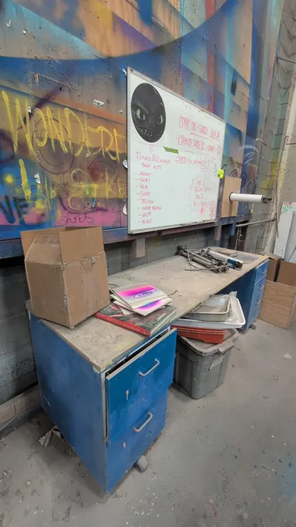 Quantity of merchandise in area. Includes 81" wood work desk with dual mobile drawer pedestals on casters, 4' x 3' wall-mounted whiteboard, wall-mount
