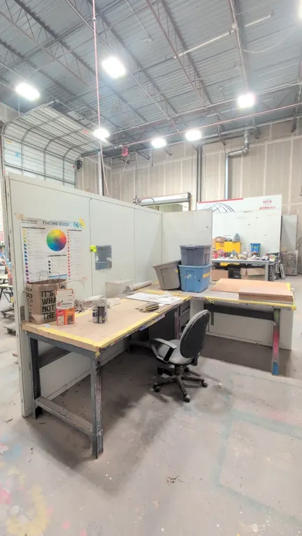Industrial workstation lot. Includes metal L-shaped workbench desk, 3-drawer filing cabinet, and freestanding utility table. Features adjustable-heigh