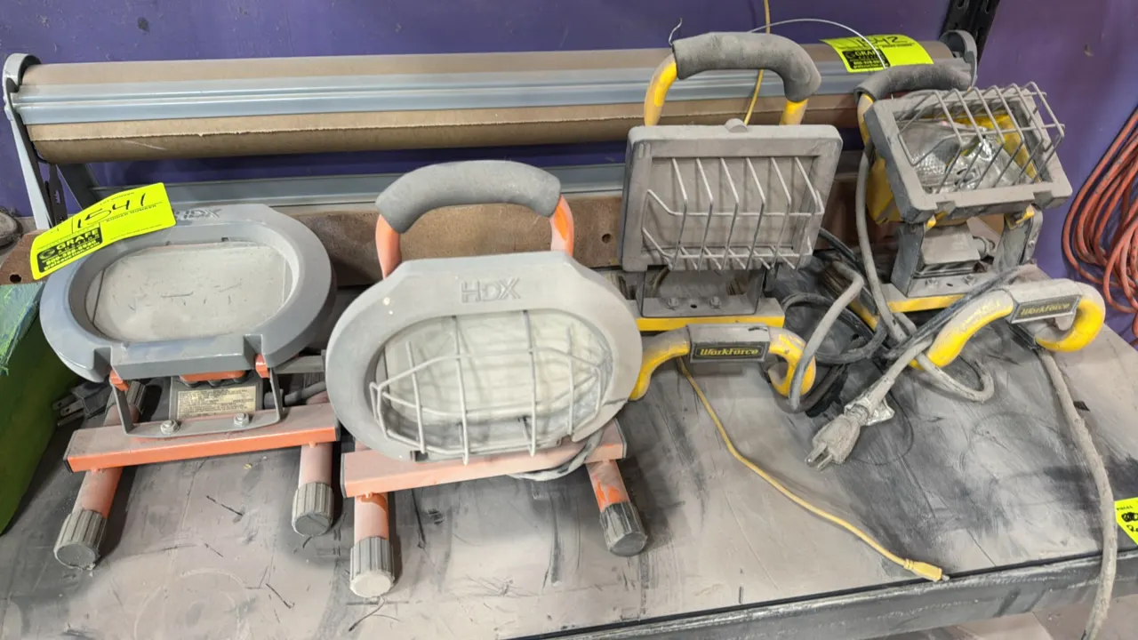 HDX and Workforce portable work lights. Features adjustable tilt heads, protective wire face guards, cushioned carry handles, and tubular metal floor