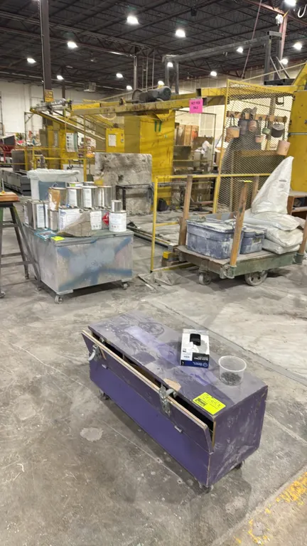 Assorted industrial wood carts. Includes a purple mobile wooden chest with latches, a heavy-duty wooden platform cart with wood upright stakes and cas