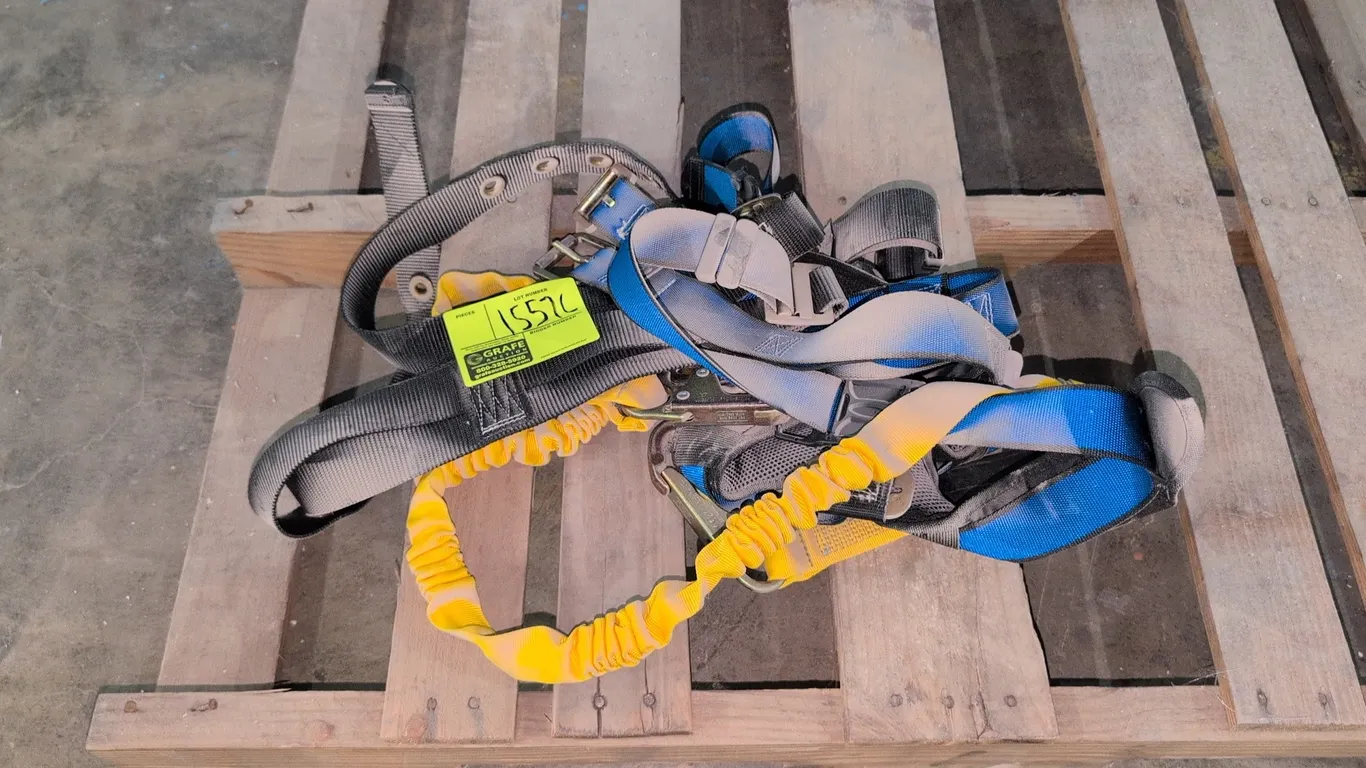FallTech fall protection safety harness. Features an attached yellow shock-absorbing lanyard, padded mesh support, adjustable blue and black webbing s