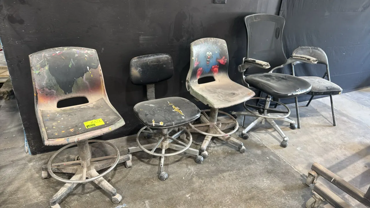 Assorted chairs. Includes (4) rolling task and drafting stools with foot rings and (1) metal folding chair with padded seat and back. Features various