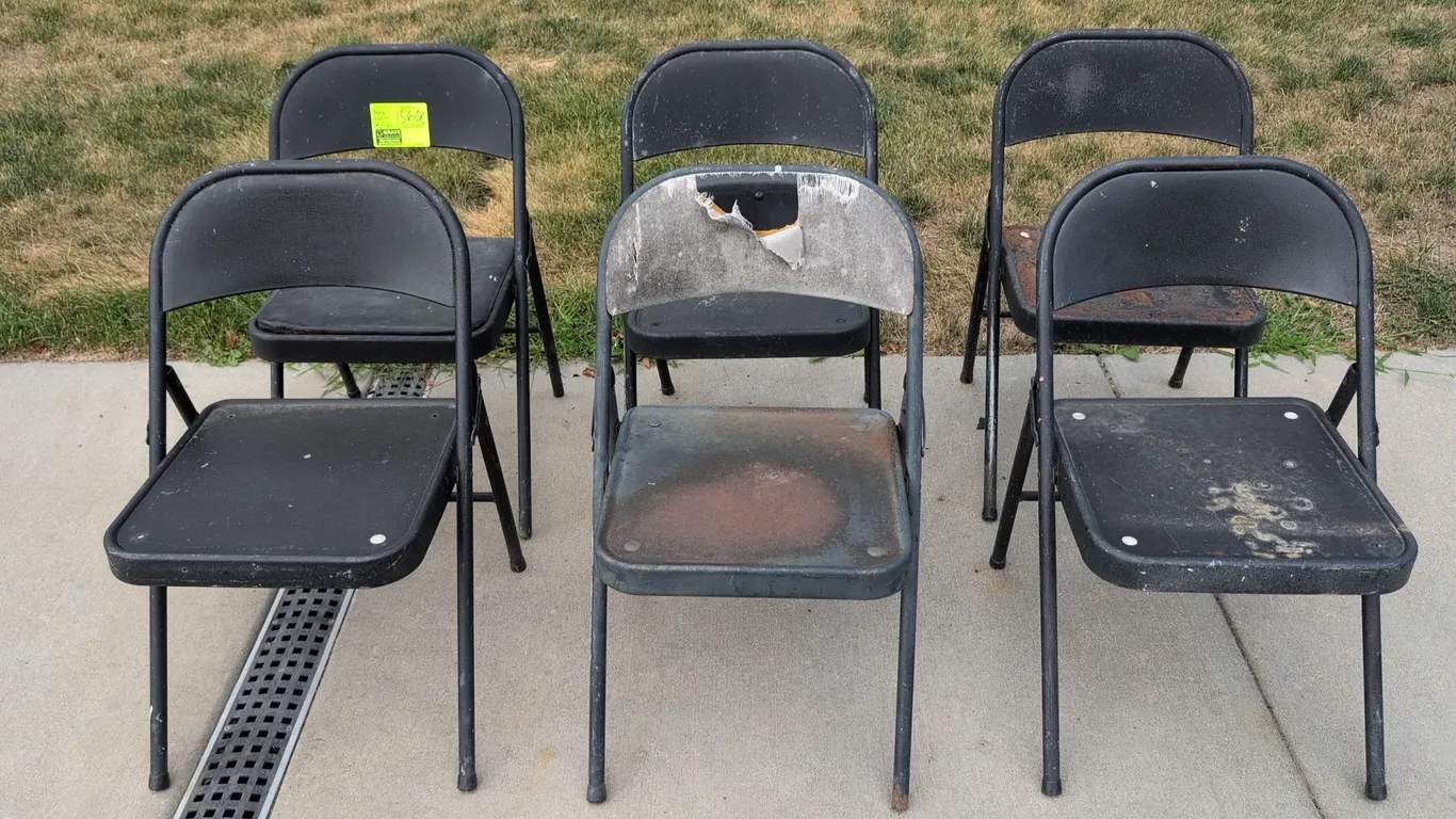 Metal folding chairs. Features black tubular metal frames with folding design. Note: Significant condition issues present across lot, including rust,